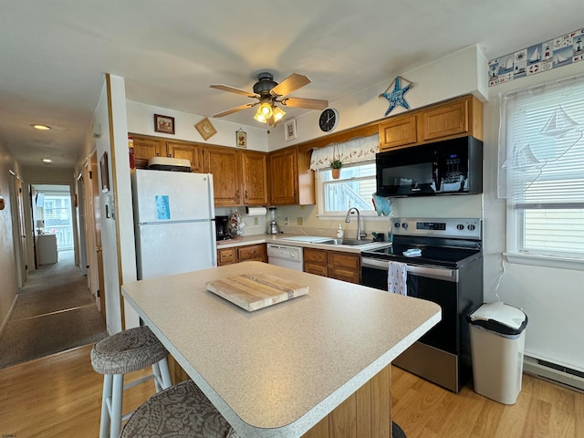 kitchen featuring sink, a center island, light hardwood / wood-style flooring, a baseboard radiator, and white appliances