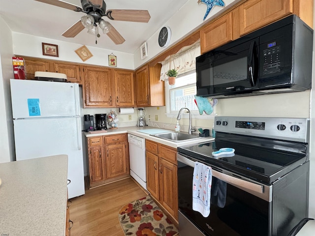 kitchen featuring ceiling fan, sink, white appliances, and light hardwood / wood-style flooring