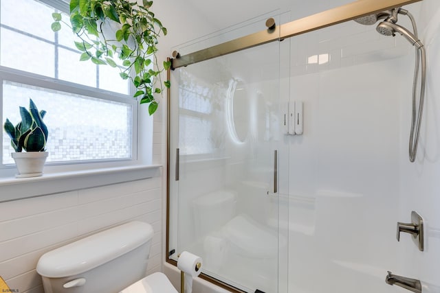 bathroom featuring tile walls and toilet