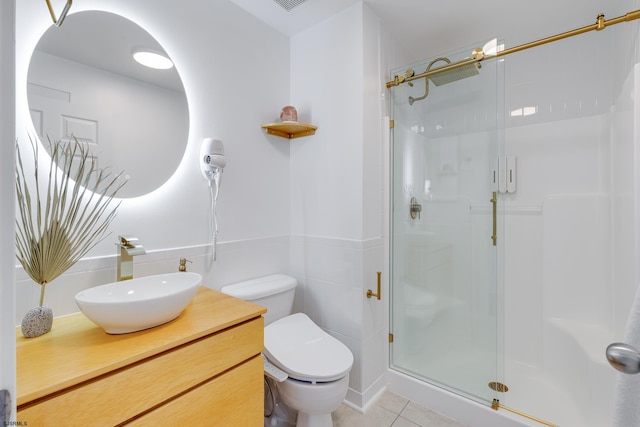 bathroom with toilet, vanity, tile patterned floors, and a shower with shower door