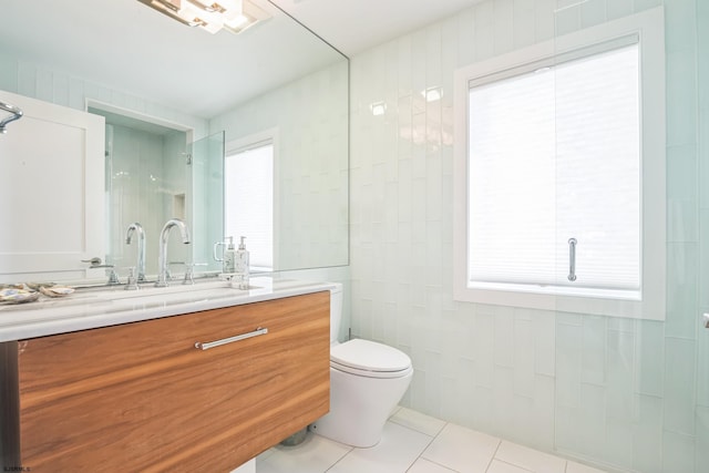 bathroom featuring toilet, vanity, tile patterned floors, and a healthy amount of sunlight