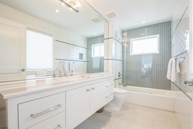 full bathroom featuring tile patterned floors, vanity, toilet, and tiled shower / bath