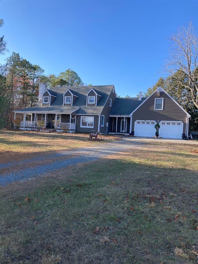 view of front facade with covered porch, a garage, and a front yard