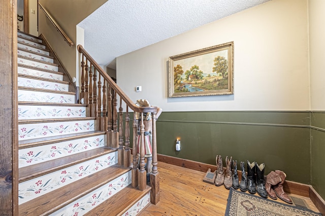 staircase featuring hardwood / wood-style flooring and a textured ceiling