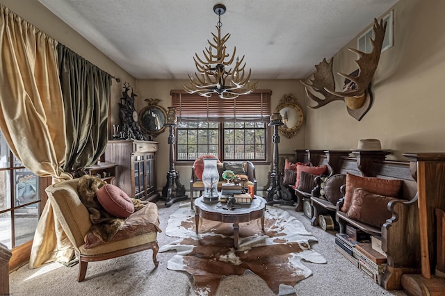 sitting room with carpet floors, a textured ceiling, and an inviting chandelier