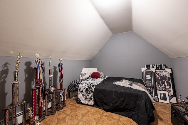 bedroom featuring light parquet floors and vaulted ceiling