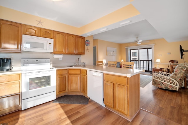 kitchen featuring white appliances, sink, light hardwood / wood-style flooring, ceiling fan, and kitchen peninsula