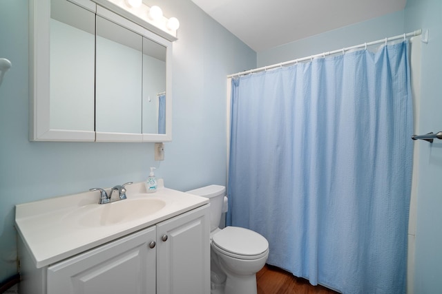 bathroom with curtained shower, hardwood / wood-style floors, vanity, and toilet