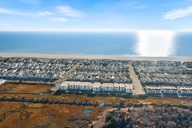 bird's eye view featuring a water view and a beach view