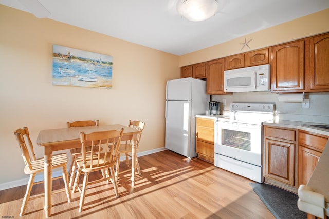 kitchen featuring light hardwood / wood-style floors, white appliances, and sink