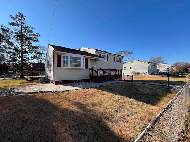 view of front of house with central air condition unit, a front yard, and a deck