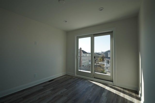 unfurnished room with dark hardwood / wood-style flooring