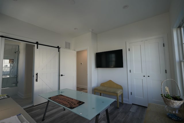 interior space with a barn door and dark wood-type flooring