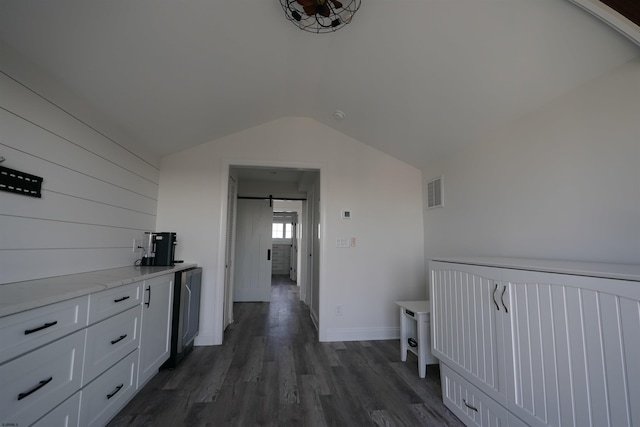 corridor featuring vaulted ceiling and dark hardwood / wood-style flooring