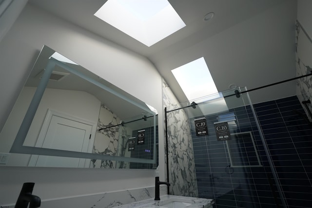 bathroom with a skylight and a tile shower