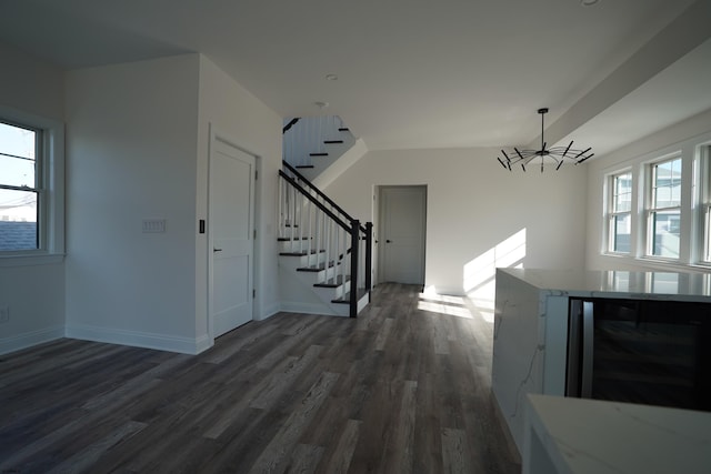 foyer entrance with beverage cooler, dark hardwood / wood-style flooring, a notable chandelier, and a healthy amount of sunlight