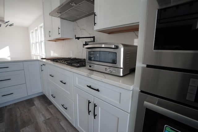 kitchen featuring stainless steel gas stovetop, white cabinetry, and dark hardwood / wood-style floors