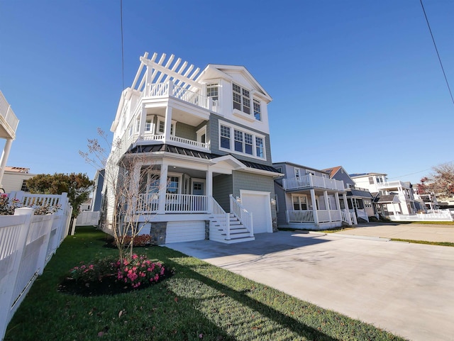 view of front of home featuring covered porch, a garage, and a balcony