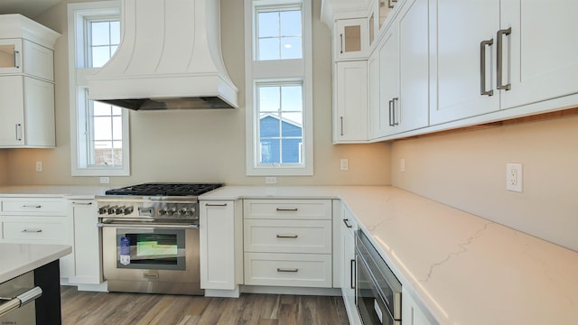 kitchen with premium range hood, white cabinetry, and stainless steel appliances