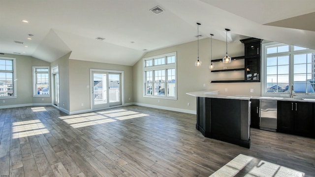 kitchen featuring sink, dark hardwood / wood-style flooring, hanging light fixtures, and vaulted ceiling