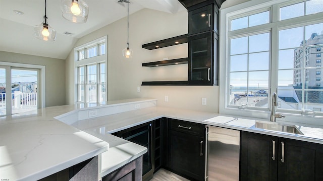 kitchen with light stone countertops, sink, decorative light fixtures, and lofted ceiling