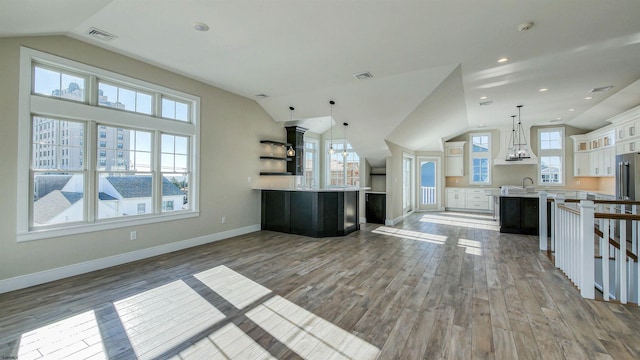 kitchen with white cabinetry, hanging light fixtures, dark hardwood / wood-style flooring, lofted ceiling, and a kitchen island