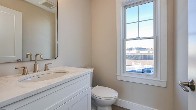 bathroom featuring vanity, toilet, and a wealth of natural light