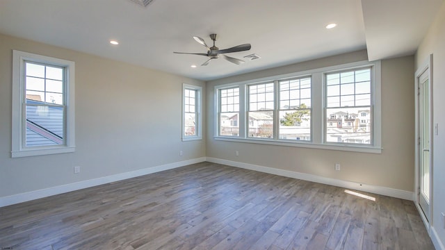 unfurnished room featuring ceiling fan, light hardwood / wood-style flooring, and a healthy amount of sunlight