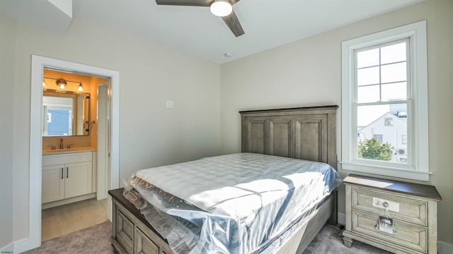 carpeted bedroom with ceiling fan, sink, and connected bathroom