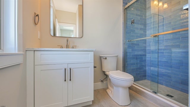 bathroom featuring hardwood / wood-style flooring, vanity, toilet, and walk in shower