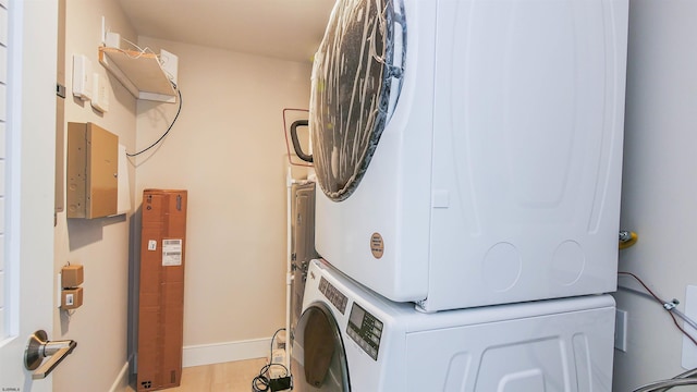 clothes washing area with stacked washer and dryer and light hardwood / wood-style flooring