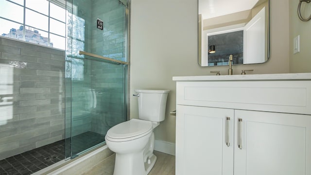 bathroom with walk in shower, vanity, wood-type flooring, and toilet