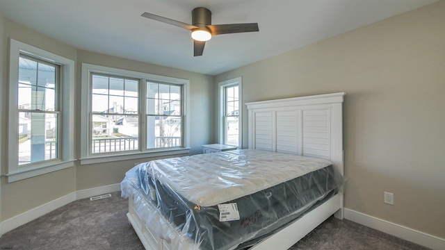 carpeted bedroom with multiple windows and ceiling fan