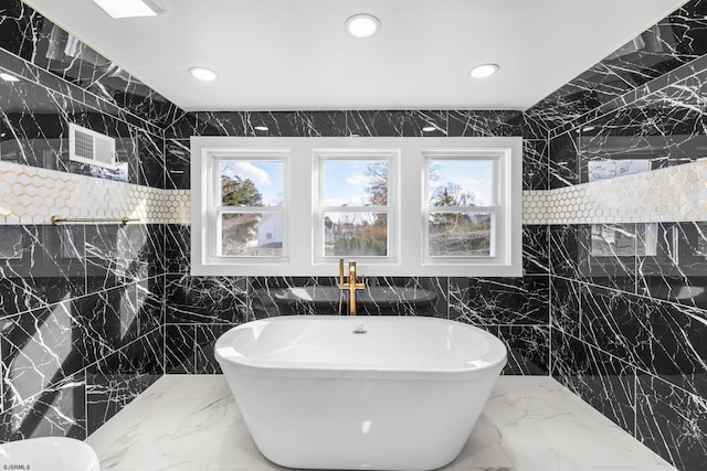 bathroom featuring a healthy amount of sunlight and tile walls