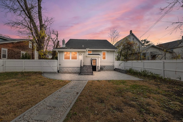 view of front of home with a lawn and a patio