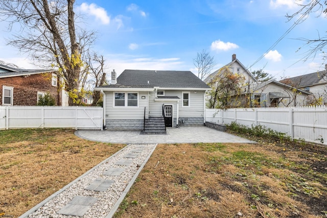 rear view of house featuring a yard and a patio area