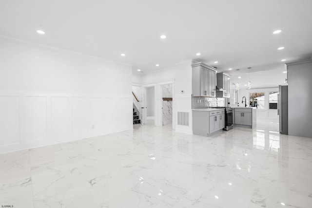 kitchen featuring appliances with stainless steel finishes, gray cabinetry, crown molding, sink, and decorative light fixtures