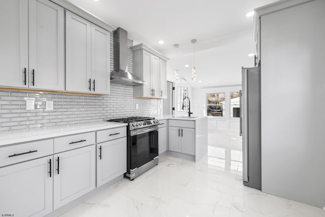 kitchen featuring gray cabinetry, sink, wall chimney exhaust hood, decorative light fixtures, and stainless steel appliances