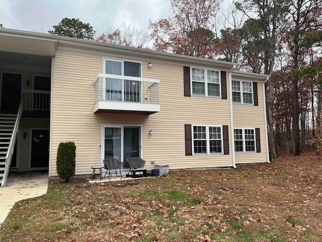 back of property with a balcony and a patio