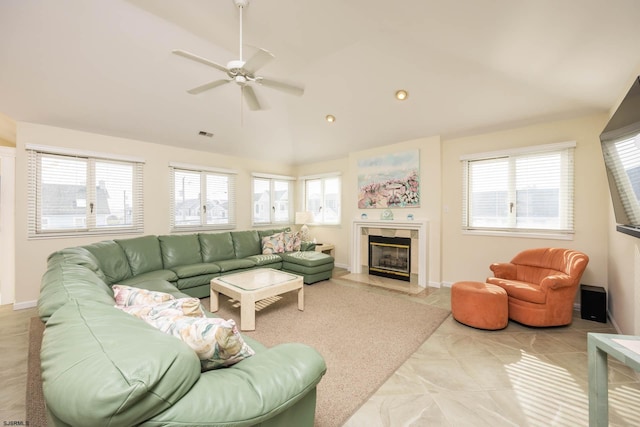 living room with a tiled fireplace, ceiling fan, plenty of natural light, and lofted ceiling