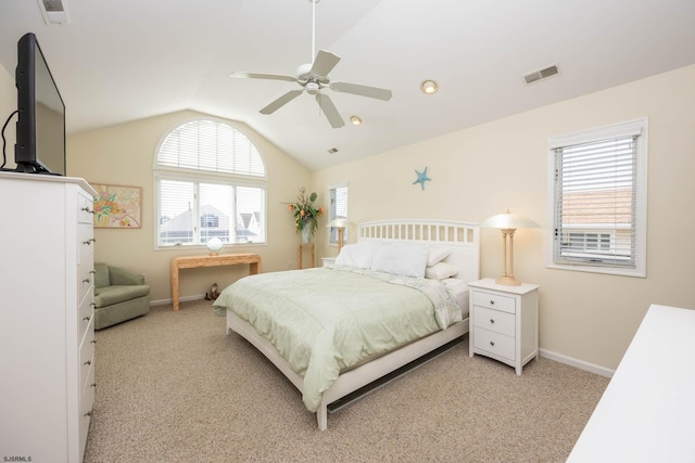 bedroom featuring light carpet, vaulted ceiling, multiple windows, and ceiling fan