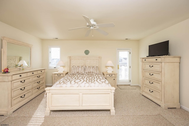 carpeted bedroom featuring multiple windows and ceiling fan