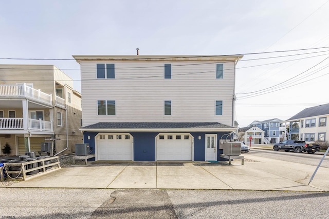 back of property with central air condition unit and a garage