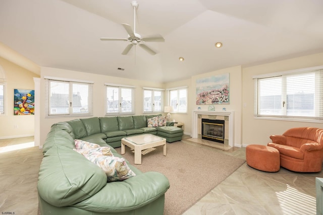 living room with a tile fireplace, vaulted ceiling, a wealth of natural light, and ceiling fan