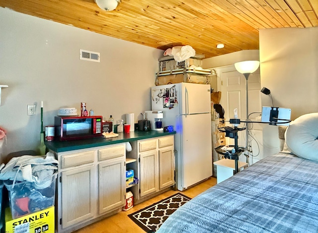 kitchen with white fridge, light wood-type flooring, and wooden ceiling