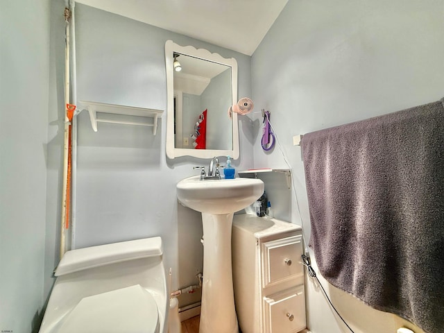 bathroom with lofted ceiling and toilet