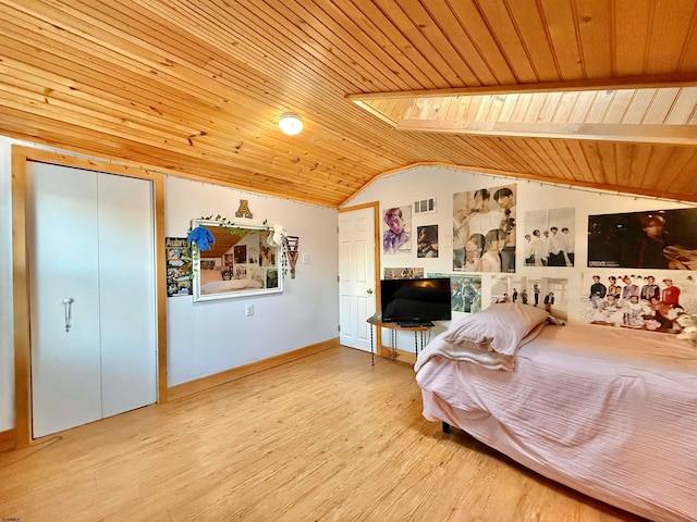 bedroom featuring a closet, vaulted ceiling with skylight, wooden ceiling, and light hardwood / wood-style floors