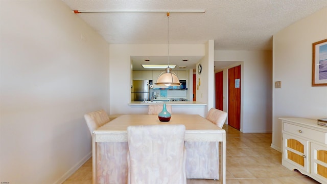 tiled dining room featuring a textured ceiling and sink