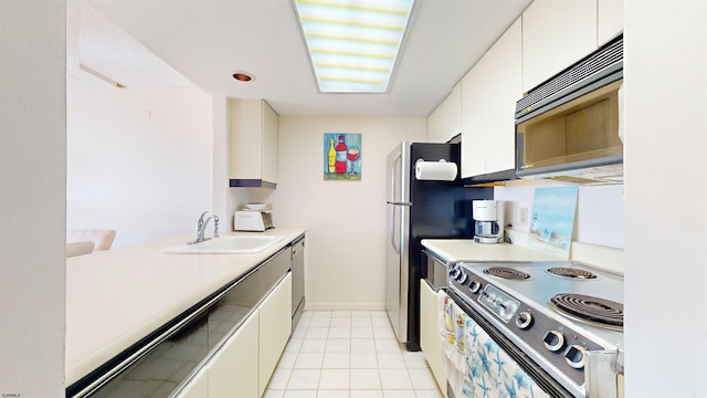 kitchen with white cabinets, stainless steel appliances, light tile patterned flooring, and sink