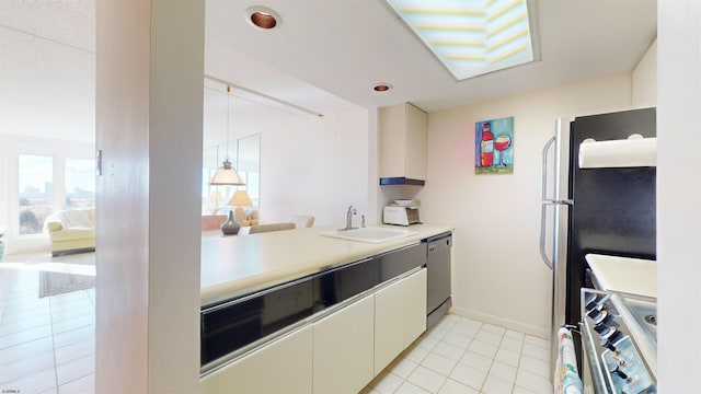 kitchen with sink, white cabinets, light tile patterned floors, and appliances with stainless steel finishes